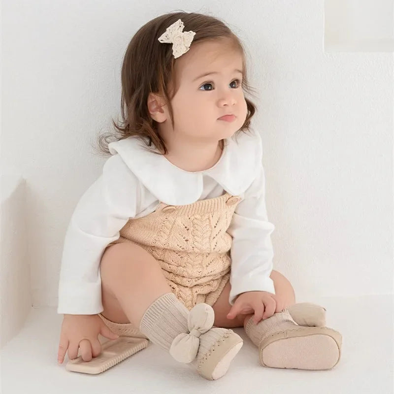 baby girl wearing pink bow sock shoes