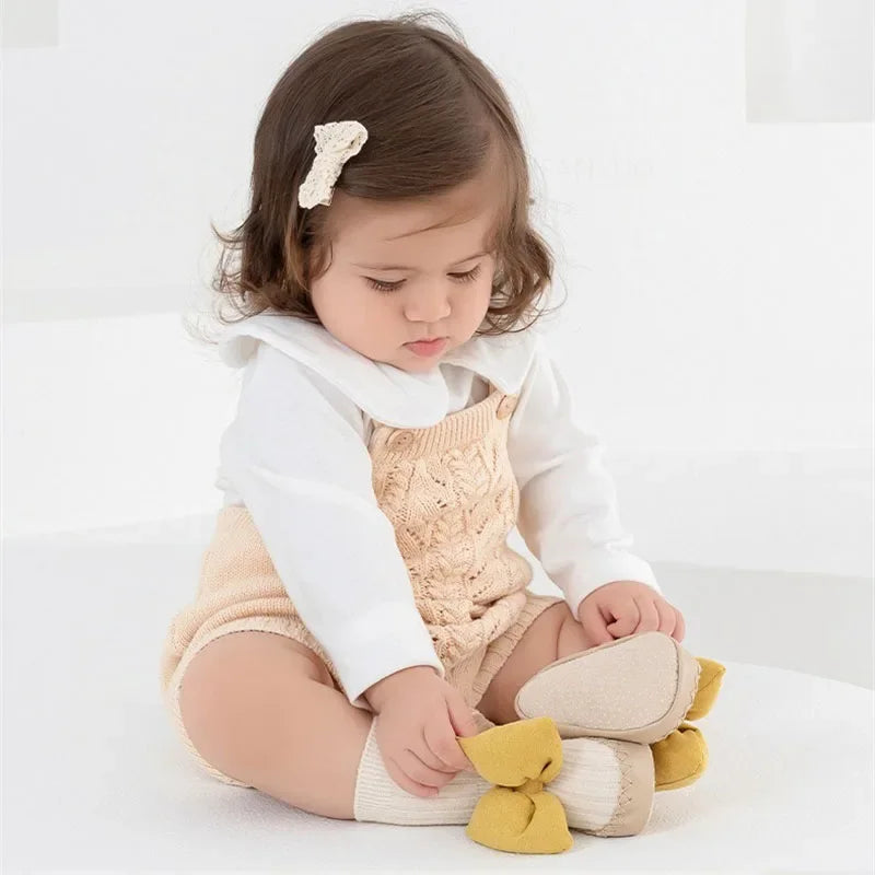 baby girl wearing pink bow sock shoes
